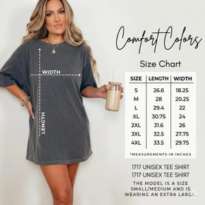 Puede incluir: Una camiseta unisex gris carb&oacute;n con una tabla de tallas. La tabla enumera las tallas de la S a la 4XL con las medidas de largo y ancho en pulgadas. El texto incluye Comfort Colors Size Chart y 1717 Unisex Tee Shirt.