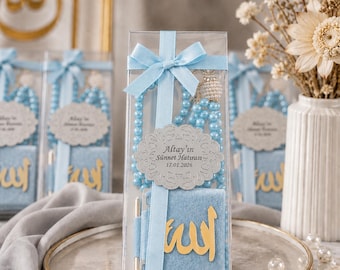 May include: A clear box tied with a light blue ribbon contains a light blue prayer beads, a small blue book with gold Arabic script, and a pen. A decorative label reads "Altay'ın Sünnet Hatırası - 17.01.2026".