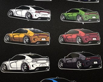 May include: A collection of car stickers in various colors, including pink, purple, white, green, yellow, red, black, and blue. Each sticker features a stylized illustration of a car with custom wheels and a white border.