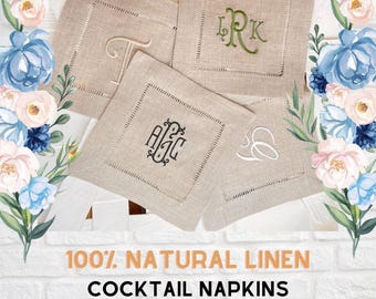 May include: Four square natural linen cocktail napkins featuring hemstitched borders and various embroidered monograms in green, black, and white thread. The text 100% NATURAL LINEN COCKTAIL NAPKINS is printed below the napkins against a white brick background.
