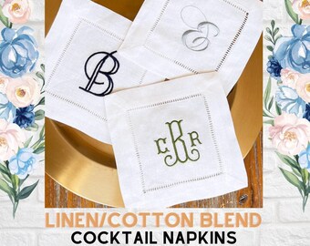 May include: Three square white linen and cotton blend cocktail napkins with hemstitched borders. Each napkin features a different embroidered monogram: a black letter B, a grey script letter E, and a green three-letter monogram CBR.