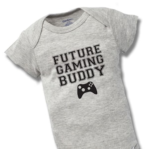May include: A gray baby onesie with black text that reads "FUTURE GAMING BUDDY" and a black video game controller graphic.