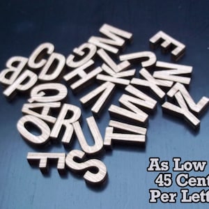 May include: Wooden letters of the alphabet in various sizes, scattered on a blue surface. The letters are made of light brown wood and have a natural grain pattern. The text "As Low As 45 Cents Per Letter!" is visible at the bottom of the image.