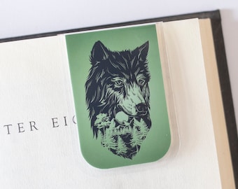 Puede incluir: Marcapáginas verde con una ilustración en blanco y negro de una cabeza de lobo con una escena de bosque detrás.