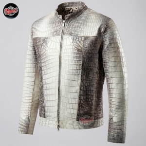 Op de afbeelding: Een witte en grijze leren jas met krokodillenstructuur, een ritssluiting over de hele lengte en een opstaande kraag. De jas heeft een uniek patroon en een logo aan de linkerbovenkant. Een stijlvolle buitenkleding.