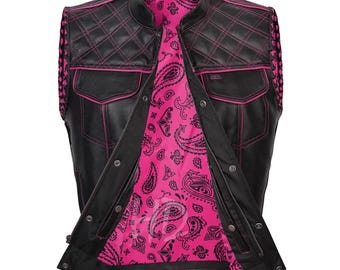 May include: Black leather vest with pink stitching and a pink paisley lining. The vest features a quilted design on the shoulders and pockets, with a zipper and snap closures. The vest has a classic biker style.