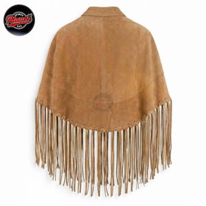 Women's genuine suede leather fringe western boho cape poncho — A tan suede poncho featuring a wide collar and a curved hemline adorned with long, thin fringe detailing. The garment is constructed with a whipstitch edge along the bottom seam where th