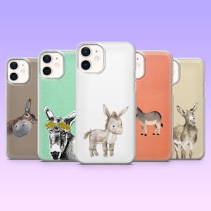 May include: Five phone cases showcasing donkey artwork. The cases display different donkey designs on various coloured backgrounds, including brown, mint green, white, orange, and beige. The donkey art styles vary from watercolour to detailed drawings.