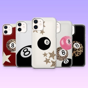 May include: A collection of phone cases featuring the number 8 billiard ball design. The cases showcase various patterns, including leopard print, a solid black ball, and a pink ball. Some cases have star accents.