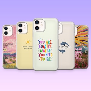 Pode incluir: Uma coleção de cinco capas de telemóvel com vários designs e citações. As capas apresentam imagens de uma paisagem, um sol, uma citação colorida, dois golfinhos e uma cena de montanha. Cada capa tem um design diferente.