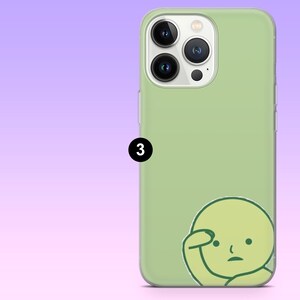 Puede incluir: Funda de tel&eacute;fono verde claro con una ilustraci&oacute;n de dibujos animados de una persona pensando. La funda tiene un acabado liso y un recorte para la c&aacute;mara. El n&uacute;mero 3 est&aacute; impreso en el lateral de la funda.