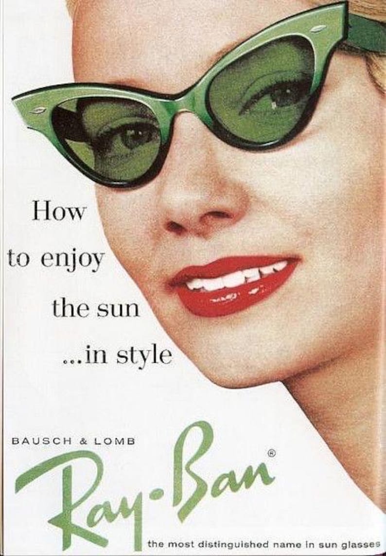 May include: Vintage advertisement featuring a woman wearing green Ray-Ban sunglasses. The sunglasses have a cat-eye shape. The ad includes the text "How to enjoy the sun...in style" and the Ray-Ban logo.