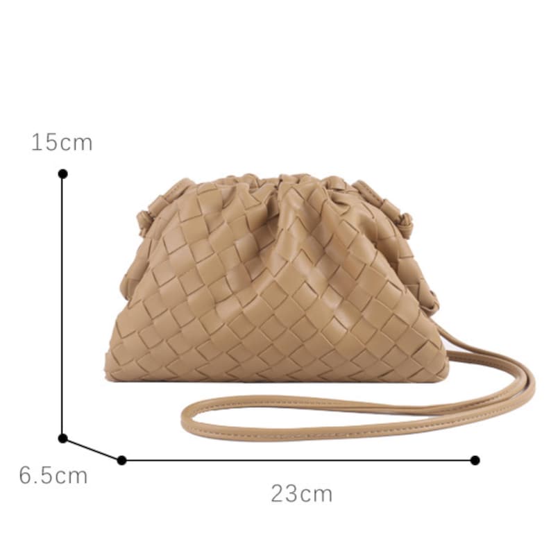 May include: A beige woven clutch bag with a drawstring closure and a long strap. The bag is approximately 23 cm long, 15 cm high, and 6.5 cm wide. The bag's design features a woven pattern.
