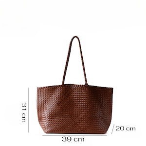 May include: A brown woven tote bag with braided handles. The bag is 39 cm wide, 31 cm tall, and 20 cm deep. The bag is made of a woven material and has a rectangular shape.