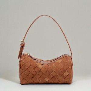 Puede incluir: Un bolso marr&oacute;n tejido con una sola correa para el hombro. El bolso tiene forma rectangular con cierre de cremallera y un patr&oacute;n tejido. La correa es fina y est&aacute; hecha de material marr&oacute;n a juego.