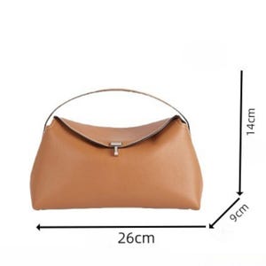 Pu&ograve; includere: Una borsa a mano marrone chiaro con manico curvo e chiusura argentata. La borsa misura 26 cm di lunghezza, 9 cm di larghezza e 14 cm di altezza. La borsa ha un design semplice ed elegante.