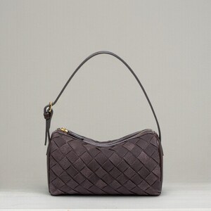 Puede incluir: Un bolso tejido marr&oacute;n oscuro con cremallera dorada y asa a juego. El bolso tiene forma rectangular y un patr&oacute;n tejido. El asa es fina y se sujeta al bolso con un peque&ntilde;o cierre dorado.