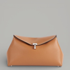 Pu&ograve; includere: Una pochette in pelle color cuoio con chiusura argentata. La borsa ha una superficie strutturata e cuciture bianche lungo i bordi. La pochette &egrave; rettangolare con la parte superiore curva.