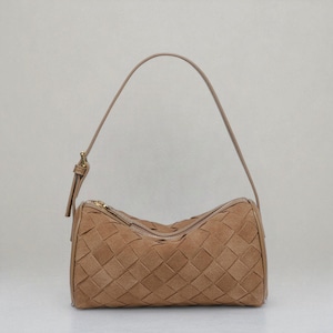 Puede incluir: Un bolso de mano de cuero tejido de color marr&oacute;n claro, con forma cil&iacute;ndrica. El bolso tiene un cierre de cremallera y una fina correa de hombro ajustable. El patr&oacute;n tejido crea una apariencia texturizada. El bolso est&aacute; dise&ntilde;ado para llevar lo esencial.