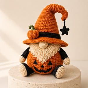 Peut inclure: Une poupée gnome au crochet avec un corps orange en forme de citrouille et un visage de jack-o'-lantern noir. Le gnome porte un grand chapeau pointu orange avec une bande noire, une petite citrouille verte et une étoile noire suspendue.