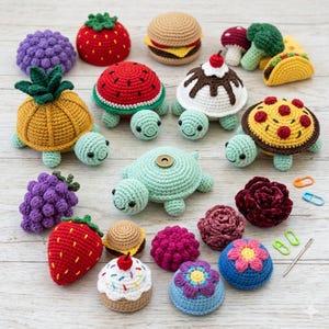 May include: A collection of various crocheted items including several small turtles with shells shaped like a pineapple, watermelon, pizza, and a sundae. Other items include crocheted strawberries, grapes, burgers, flowers, and a mushroom, alongside a needle and stitch markers.