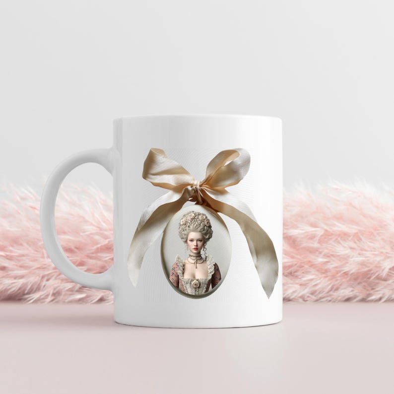 May include: A white ceramic mug featuring a central oval portrait of a person with an elaborate powdered wig and period clothing. A large, light beige satin ribbon is tied in a bow above the oval frame, draping down the sides of the image.