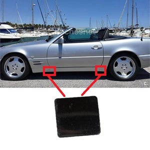 Può includere: Una piccola copertura quadrata in plastica nera progettata per la minigonna laterale di un'auto decappottabile color argento. L'immagine mostra il profilo laterale dell'auto con due riquadri rossi che indicano la posizione di montaggio.