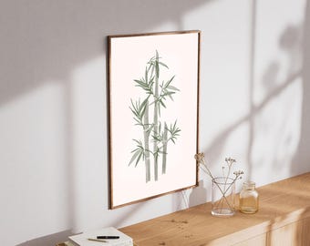 Könnte beinhalten: Ein gerahmter Kunstdruck mit einer Aquarellillustration von Bambusstängeln und Blättern in Grün- und Grautönen. Das Kunstwerk wird vor einem weißen Hintergrund in einem braunen Holzrahmen präsentiert. Der Druck ist an einer weißen Wand über einer Holzoberfläche angebracht.