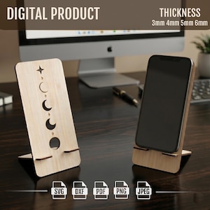 May include: Two wooden phone stands with a celestial design. One stand features cut-out crescent moon phases and a star. The other stand holds a black smartphone. The text "DIGITAL PRODUCT" and "THICKNESS 3mm 4mm 5mm 6mm" are visible.