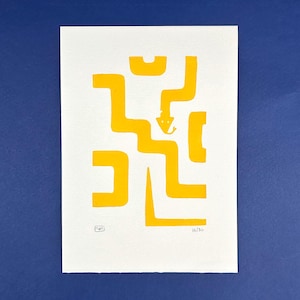Op de afbeelding: Een gele abstracte kunstprint op wit papier, met een doolhofachtig ontwerp met geometrische vormen. De print is genummerd 16/50 en bevat een klein kunstenaarsteken. Het kunstwerk staat tegen een diepblauwe achtergrond.