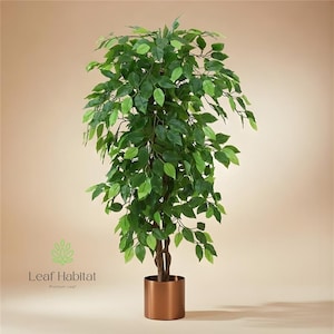 May include: An artificial ficus tree with vibrant green foliage and a brown trunk, set in a copper-coloured cylindrical pot. The logo "Leaf Habitat" is visible. The tree is a decorative indoor plant.