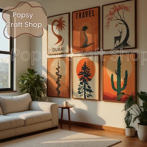 May include: A collection of framed art prints featuring travel-themed illustrations. The prints showcase desert landscapes, trees, and a deer, with text that reads "DUBAI" and "TRAVEL". The color palette includes orange, brown, and green.