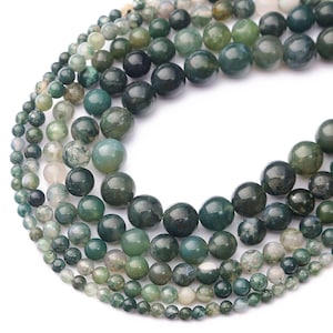Puede incluir: Cadenas de cuentas de piedra preciosa de ágata musgosa en varios tamaños y tonos de verde, blanco y gris. Las cuentas tienen una apariencia natural veteada, adecuadas para la fabricación de joyas.
