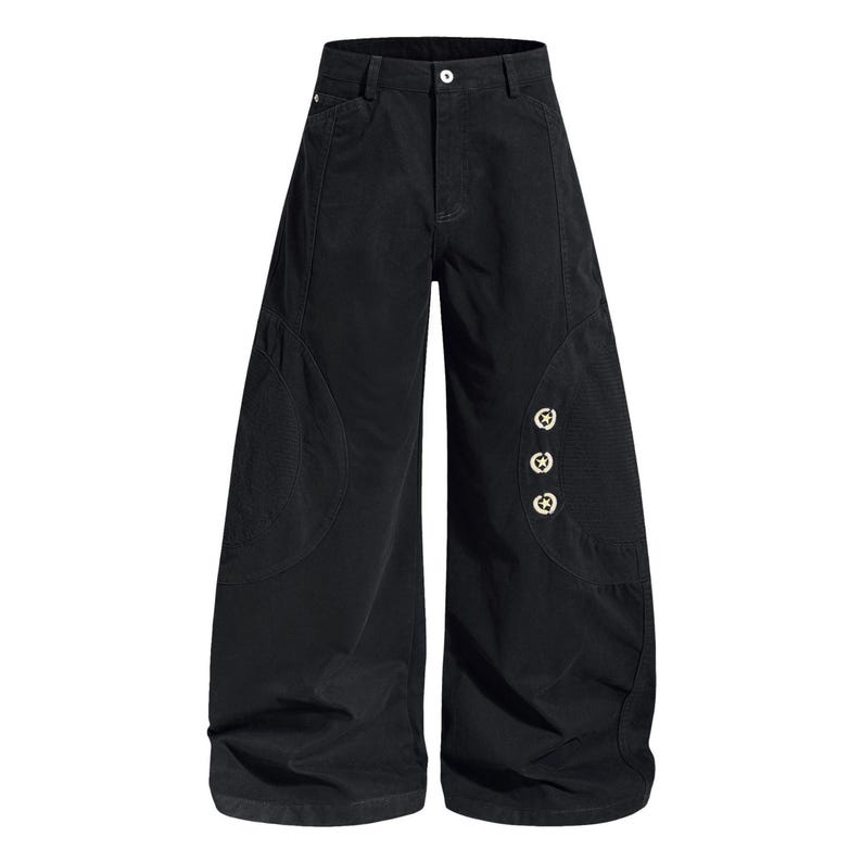 Op de afbeelding: Zwarte broek met wijde pijpen, hoge taille en knoopsluiting. De broek heeft afgeronde zakdetails en drie decoratieve stervormige knopen aan de zijkant. De stof lijkt een lichtgewicht materiaal te zijn.