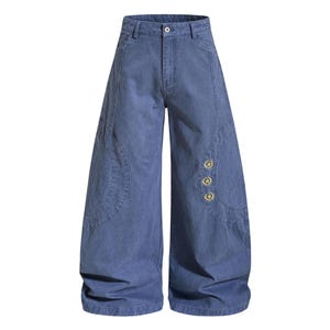 Op de afbeelding: Blauwe denim broek met wijde pijpen, knoop- en zakdetails. De broek heeft een hoge taille en een relaxte pasvorm. Drie goudkleurige sterknopen sieren de zijkant.