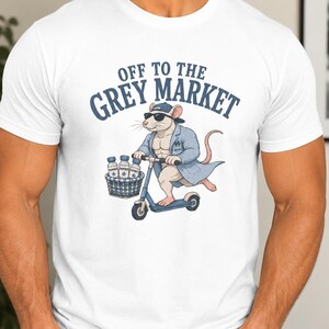 May include: A white t-shirt featuring a graphic of a muscular rat wearing sunglasses, a blue cap, and a blue coat while riding a blue scooter. The rat has a basket containing three bottles. The text above the rat reads OFF TO THE GREY MARKET.