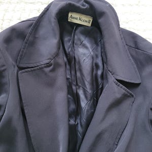 May include: A navy blue blazer with a label that reads "Anne Klein II" on the inside collar.