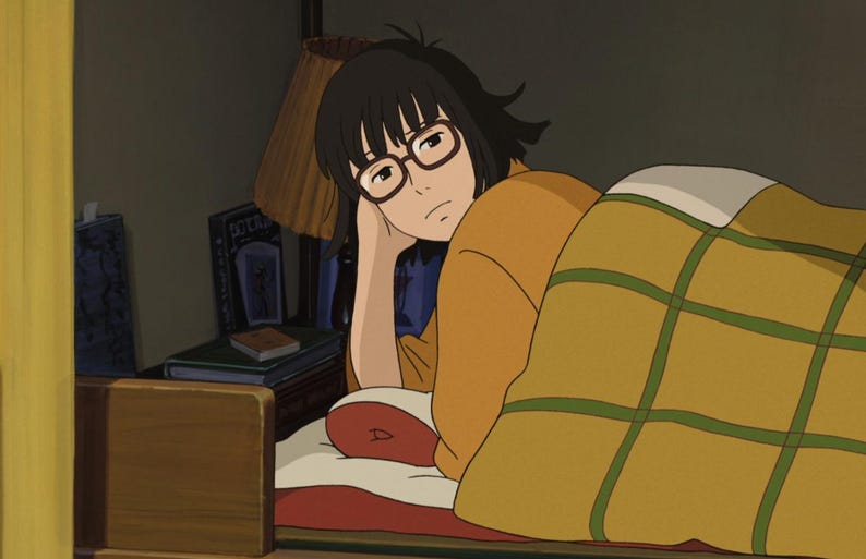 May include: An animated illustration of a person in bed, wearing glasses and an orange shirt, resting their head on their hand. A yellow blanket with green grid lines covers the person. Books and a lamp are visible in the background.