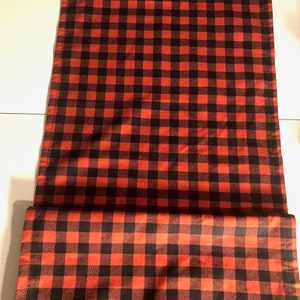 Puede incluir: Tela a cuadros rojos y negros. La tela está doblada por la mitad, mostrando el patrón en ambos lados.