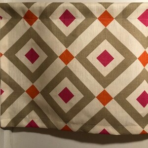 May include: A valance with a geometric pattern of orange, pink, and brown diamonds on a white background.