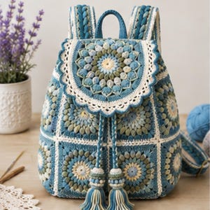 May include: A crochet backpack featuring a blue, green, and cream mandala-style pattern. The bag is constructed from square motifs with a scalloped flap, a drawstring closure with two large tassels, and braided shoulder straps in matching colours.