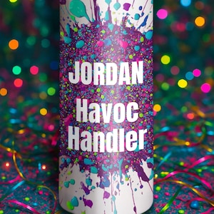 May include: A white tumbler with a colorful splatter design in teal, purple, and pink. The text "JORDAN Havoc Handler" is displayed in white. The tumbler has a silver rim and is decorated with confetti and ribbons.