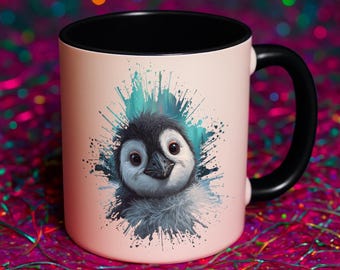 以下が含まれることがあります： 淡いピンク色の外側、黒色の内側、黒色の持ち手が付いたセラミックマグ。マグには、ターコイズブルーの飛沫を背景にしたペンギンの水彩イラストが描かれています。「Mess Made Pretty」の文字がマグにあります。