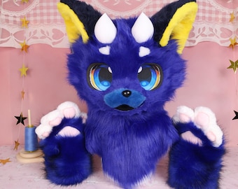 Cabeza de fursuit estilo Kemono en azul real con ojos que siguen la mirada, cuernos blancos y orejas negras y amarillas. Accesorio de peluche suave para eventos de cosplay y fans.