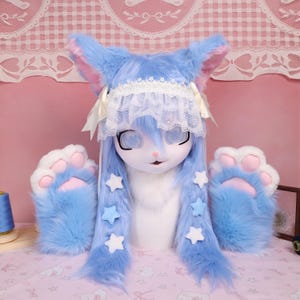 May include: A blue and white furry cosplay set featuring a headpiece with long blue hair, pink-lined ears, and a lace headband. The set includes matching paw-shaped mittens with pink pads and white fur.