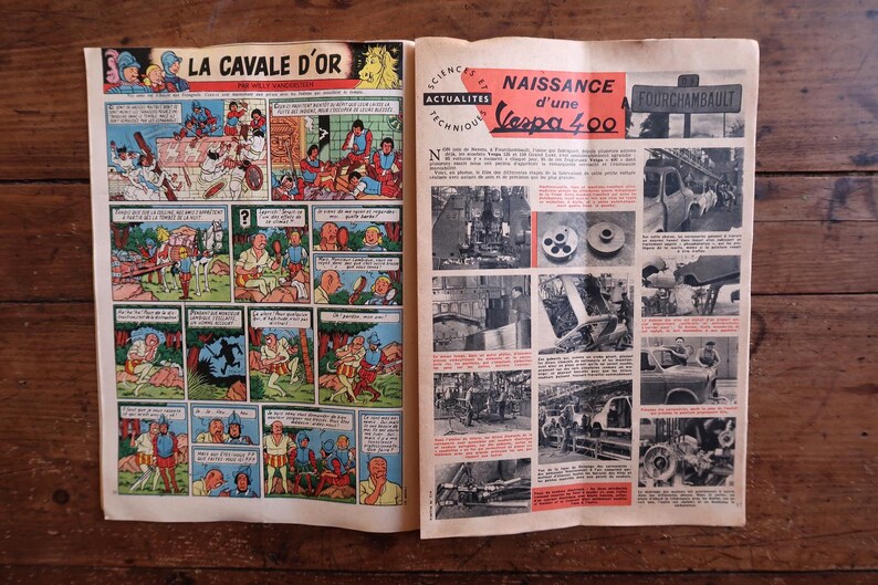 May include: A vintage magazine open on a wooden surface, displaying a comic strip titled "LA CAVALE D'OR" and articles about the Vespa 400. The comic strip is in colour, and the articles are in black and white with red highlights.