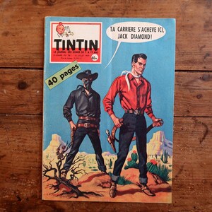 May include: Vintage comic book cover of "Tintin" featuring two cowboys in a desert landscape. One cowboy wears a black outfit and mask, the other a red shirt. Text includes "40 pages" and a speech bubble.
