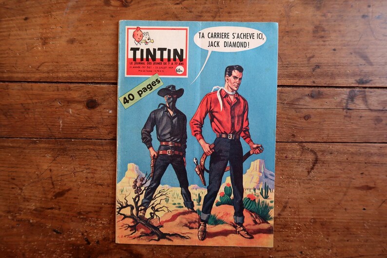 May include: Vintage comic book cover of "Tintin" featuring two cowboys in a desert landscape. One cowboy wears a black outfit and mask, the other a red shirt. Text includes "40 pages" and a speech bubble.