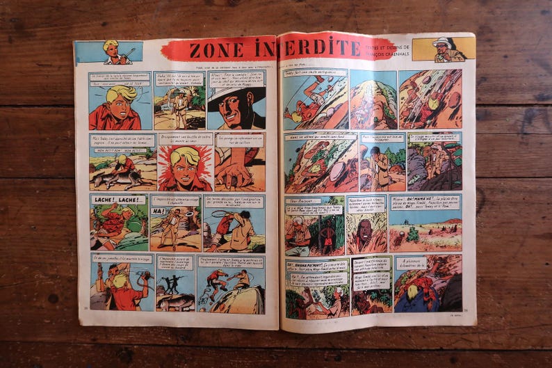 Peut inclure: Une double page de bande dessin&eacute;e vintage intitul&eacute;e ZONE INTERDITE, compos&eacute;e de vignettes color&eacute;es illustrant des sc&egrave;nes d'action avec des personnages, dont une personne blonde en chemise rouge, des paysages d&eacute;sertiques et des bulles de texte.