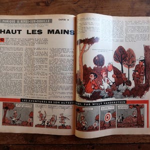 Puede incluir: P&aacute;gina doble de c&oacute;mic vintage abierta, con texto e ilustraciones en franc&eacute;s. El t&iacute;tulo "HAUT LES MAINS" es prominente. El c&oacute;mic presenta vi&ntilde;etas coloridas que representan personajes en varias escenas, sobre un fondo de madera r&uacute;stica.